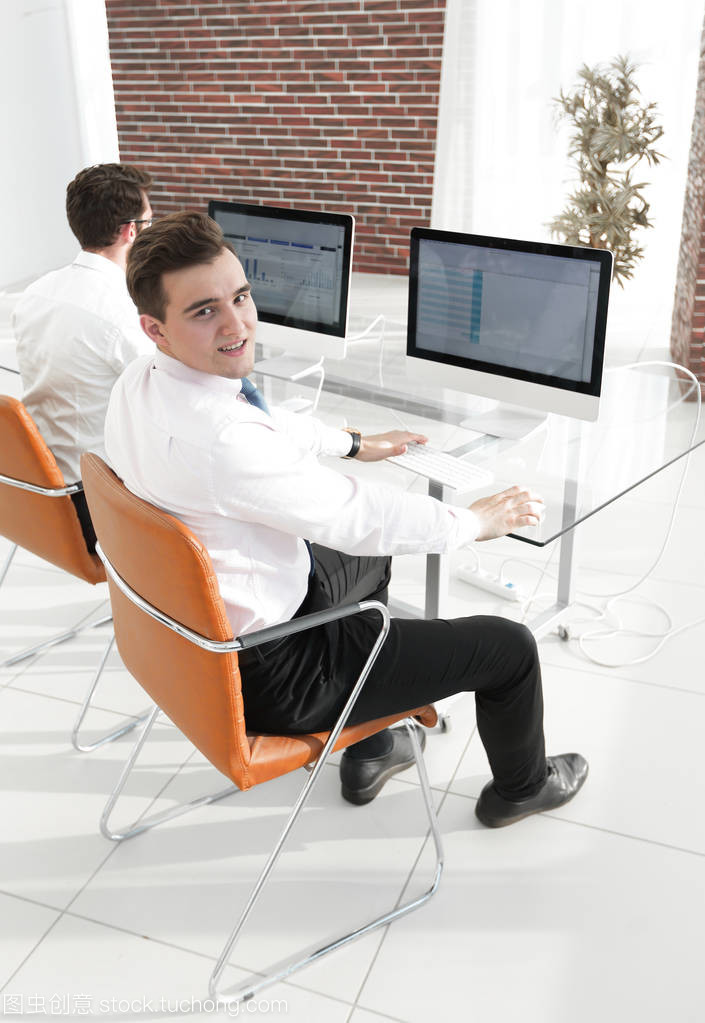 坐在桌子后面的办公室生活 员工与办公设备